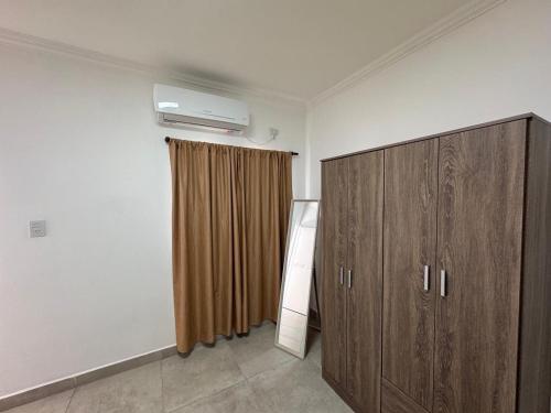 Una habitación con armarios de madera y aire acondicionado. en Departamento en alquiler temporario, en Fernández