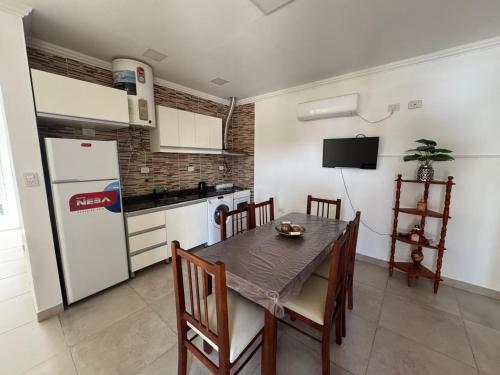 cocina con mesa de comedor y nevera en Departamento en alquiler temporario, en Fernández