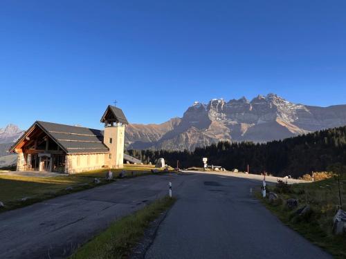 an empty road with a building and mountains in the background at Champoussin A'part in Champoussin