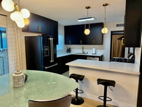 a kitchen with black cabinets and a table with chairs at In The Heart Of Las Vegas Yet Away From The Noise in Las Vegas