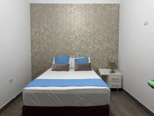 a bedroom with a large bed with blue pillows at LA CASA de DERY EN MANCORA in Máncora