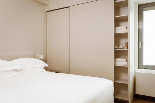 a bedroom with a white bed and a closet at Likno Athens in Athens