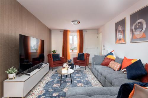 a living room with a couch and a tv at High Life Stays in Broughton