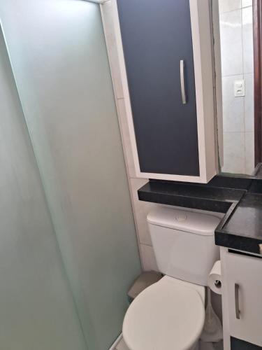 a small bathroom with a toilet and a cabinet at Bella Vida in Garanhuns