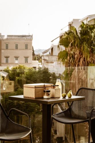 a table with a box on it with two chairs at Likno Athens in Athens