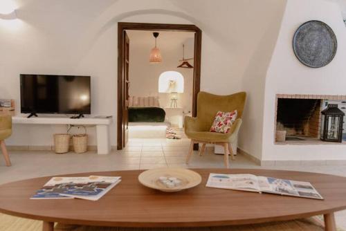 a living room with a table and a fireplace at Anedosa Cave House in Santorini