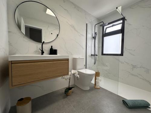 a bathroom with a sink and a toilet and a mirror at Beach Dúplex Costa Teguise in Costa Teguise