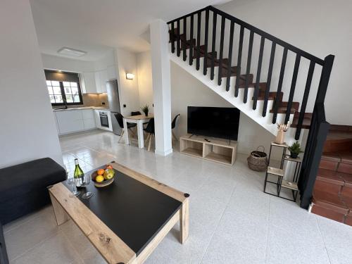 a living room with a table and a staircase at Beach Dúplex Costa Teguise in Costa Teguise