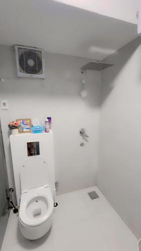 a white bathroom with a toilet and a sink at Modern Shared Studio in Heart of Zamalek in Cairo