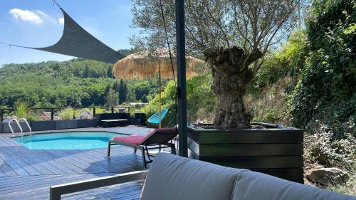 un patio avec un arbre et une piscine dans l'établissement La Closerie du Château - Vignoble à 10mn de COLMAR, à Katzenthal
