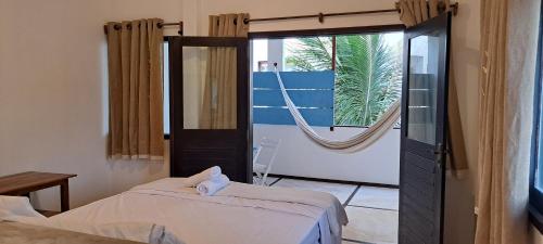 a bedroom with a bed and a large window at Vento do Ceará -Kitesurfing House- Preá in Prea