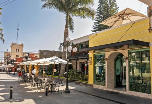 a street with tables and chairs and a palm tree at Hotel Boutique Típico in Orizaba