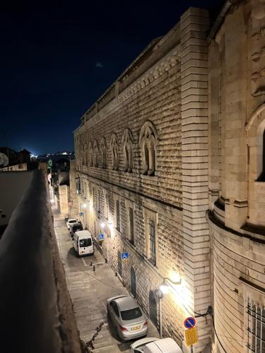 a building with cars parked on a street at night at Petrakis Inn in Jerusalem