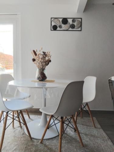 a white dining room with a white table and chairs at Aconchego Alojamento Local in Nazaré