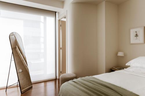 a bedroom with a bed and a large window at Likno Athens in Athens