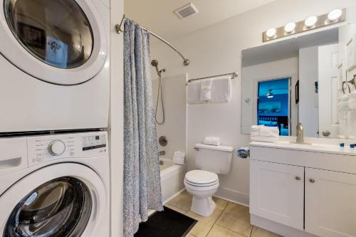 a white bathroom with a washing machine in it at Veranda 101 in Fort Walton Beach