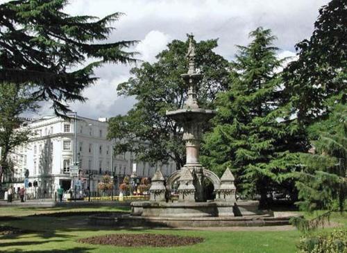 a fountain in a park in front of a building at New Stylish 4-Bed-WiFi-Free Parking in Leamington Spa
