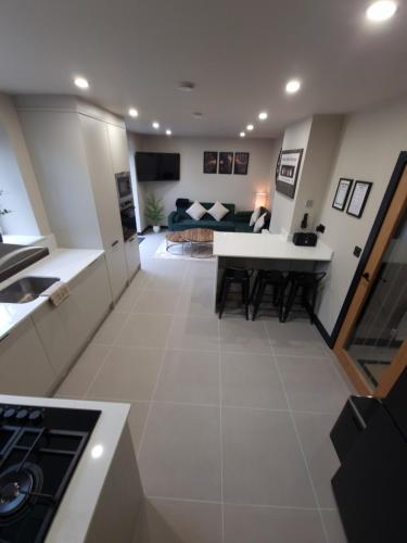 a kitchen and living room with a table and a couch at New Stylish 4-Bed-WiFi-Free Parking in Leamington Spa