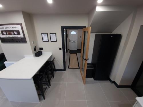 a kitchen with a white counter and a black refrigerator at New Stylish 4-Bed-WiFi-Free Parking in Leamington Spa
