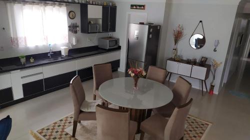 a kitchen with a table and chairs and a refrigerator at Apto vista mar in Balneário Camboriú