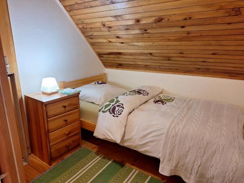a bedroom with two beds and a wooden wall at Pohorje Zen Garden in Pohorje