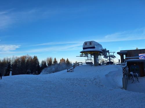 a snow covered hill with a observatory on top of it at Pohorje Zen Garden in Pohorje