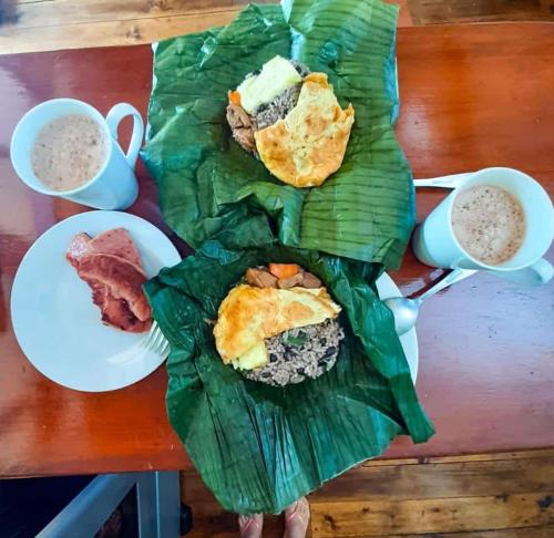 a table with two plates of food and two cups of coffee at Aloha chirripo cabaña familiar in Convento