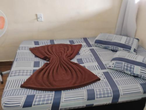 a brown dress is laying on a bed at Pousada Familia Aparecida in Aparecida