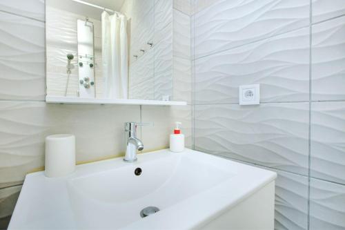 a white bathroom with a sink and a mirror at T2 cosy et moderne proche Confluence in Oullins