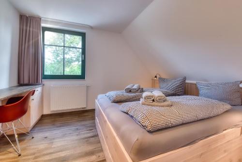 una camera da letto con un letto con asciugamani sopra di Ferienhaus Bootshaus in Nadelitz a Putbus
