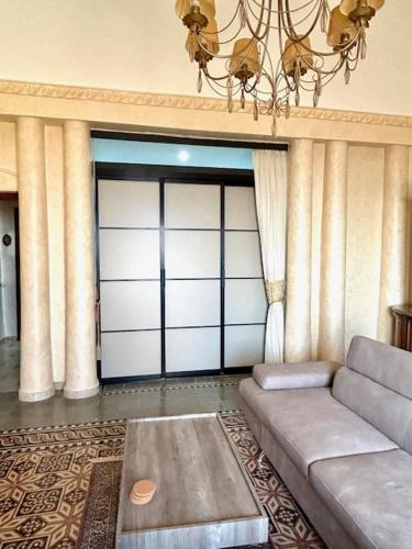 a living room with a couch and a garage door at Mussomeli Palazzo in Mussomeli