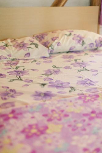 a bed with a flowered blanket with flowers on it at Sitio Holistico Natureza Sanadora in Morro Reuter
