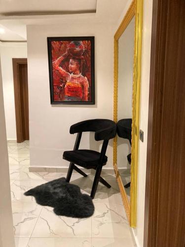 a black chair sitting in a room with a mirror at OD Cribs Luxury Apartment and On demand Car Service in Aso