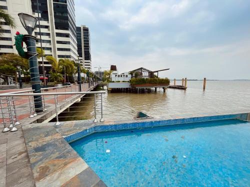 a swimming pool next to a body of water at Gallery Suite en Riverfront Puerto Santa Ana in Guayaquil