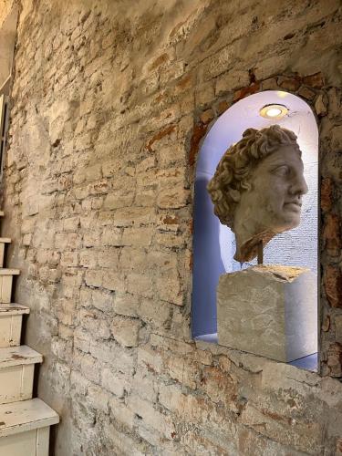 a statue of a head on a wall at Charming and Design Attic Loft Central Milan in coolest area Navigli Ticinese in Milan
