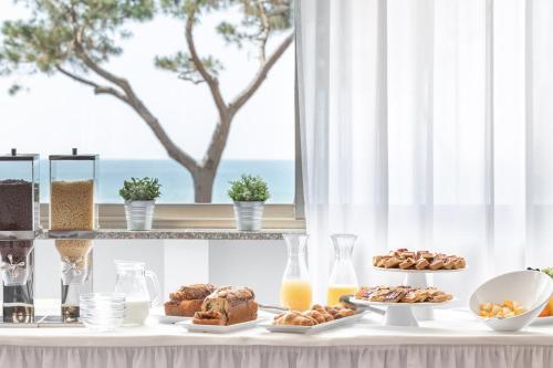 a table topped with plates of pastries and orange juice at Hotel Serapo in Gaeta