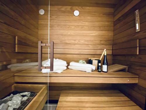 a sauna with towels and wine bottles on a shelf at Ferienwohnung Luxus Sonnensuite in der Strandvilla Charlotte Binz in Binz