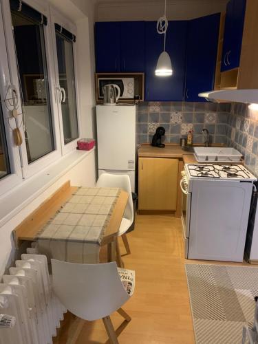 a kitchen with a table and a kitchen with blue cabinets at Your Home 7 with parking in Myslava