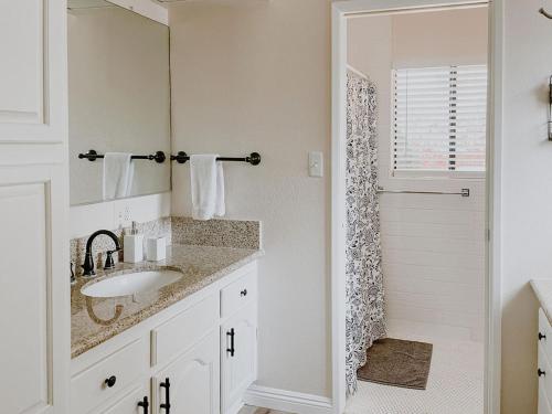 a white bathroom with a sink and a shower at San Diego Trail Guest Ranch in Poway
