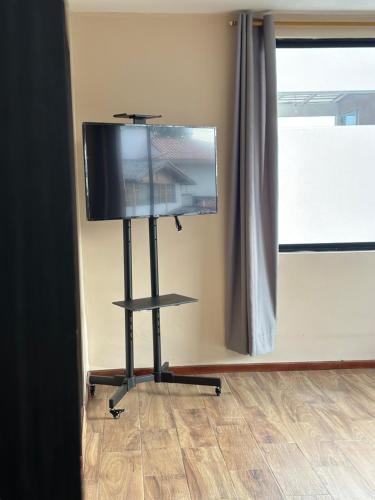 a flat screen tv on a stand in a room at San Benito B&B cerca Quito Aeropuerto - Tumbaco in Tumbaco