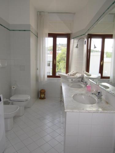 a white bathroom with a toilet and a sink at La casa di Lori in San Benedetto del Tronto