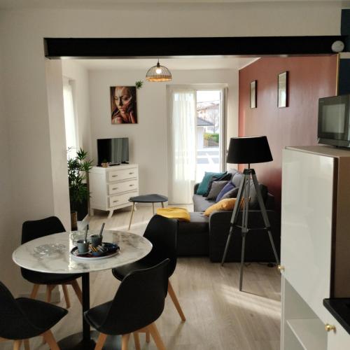 un salon avec un canapé et une table dans l'établissement Appartement verdoyant au bord du lac Leman entre Evian et Thonon dans une Villa, à Publier