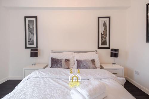 a bedroom with a large white bed with two night stands at Portland Pad - SJA Stays - Modern 2 Bed Apartment in Aberdeen