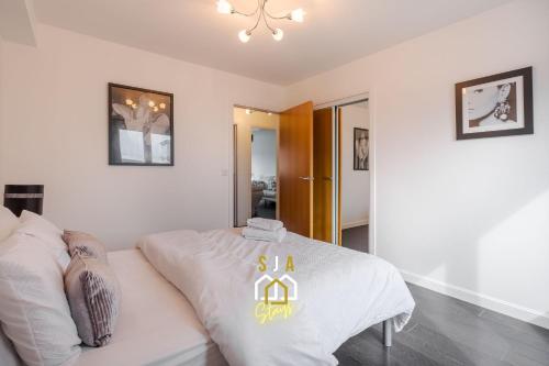 a bedroom with a white bed with a sign on it at Portland Pad - SJA Stays - Modern 2 Bed Apartment in Aberdeen