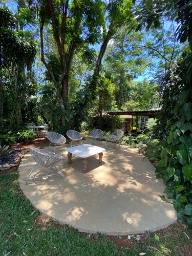 a picnic table and chairs on a concrete patio at Spa Orgânico Vegetariano Chalé Aroeiras in Jundiaí