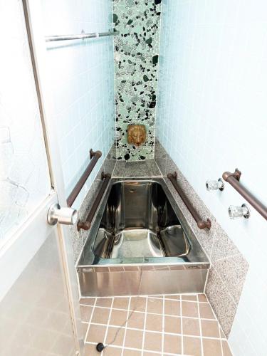 a metal sink in a bathroom with a tiled floor at TRIANGLEosaka in Osaka