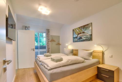 een slaapkamer met een bed en een raam bij Ferienwohnung Meereslauschen in der Villa Beatrice in Binz