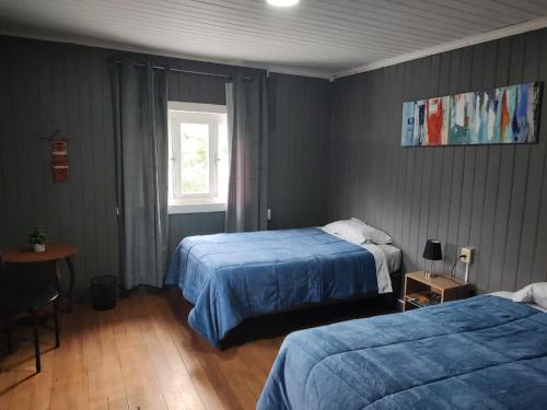 a bedroom with two beds and a window at Hostal La Casona Ensenada con parking in Ensenada