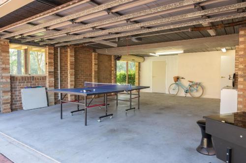 a ping pong table in a large room with a bike at Beaches n Birdies in Mollymook