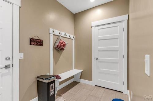 a bathroom with a white door and a trash can at Townhome Modern in Pueblo